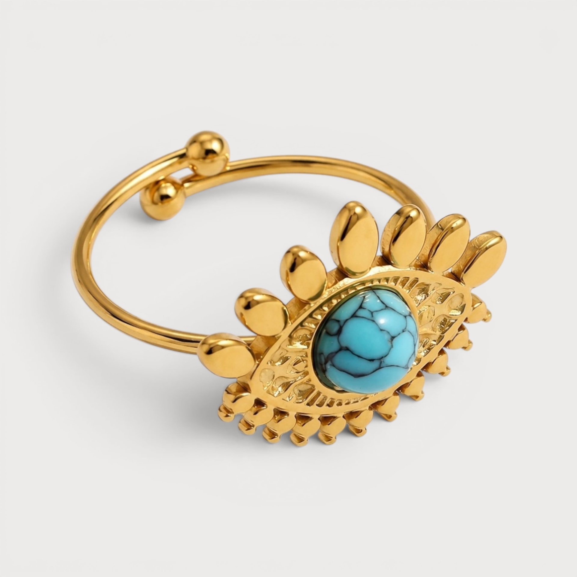 Bague Régine dorée, œil ajouré autour d’une pierre ovale bleu turquoise