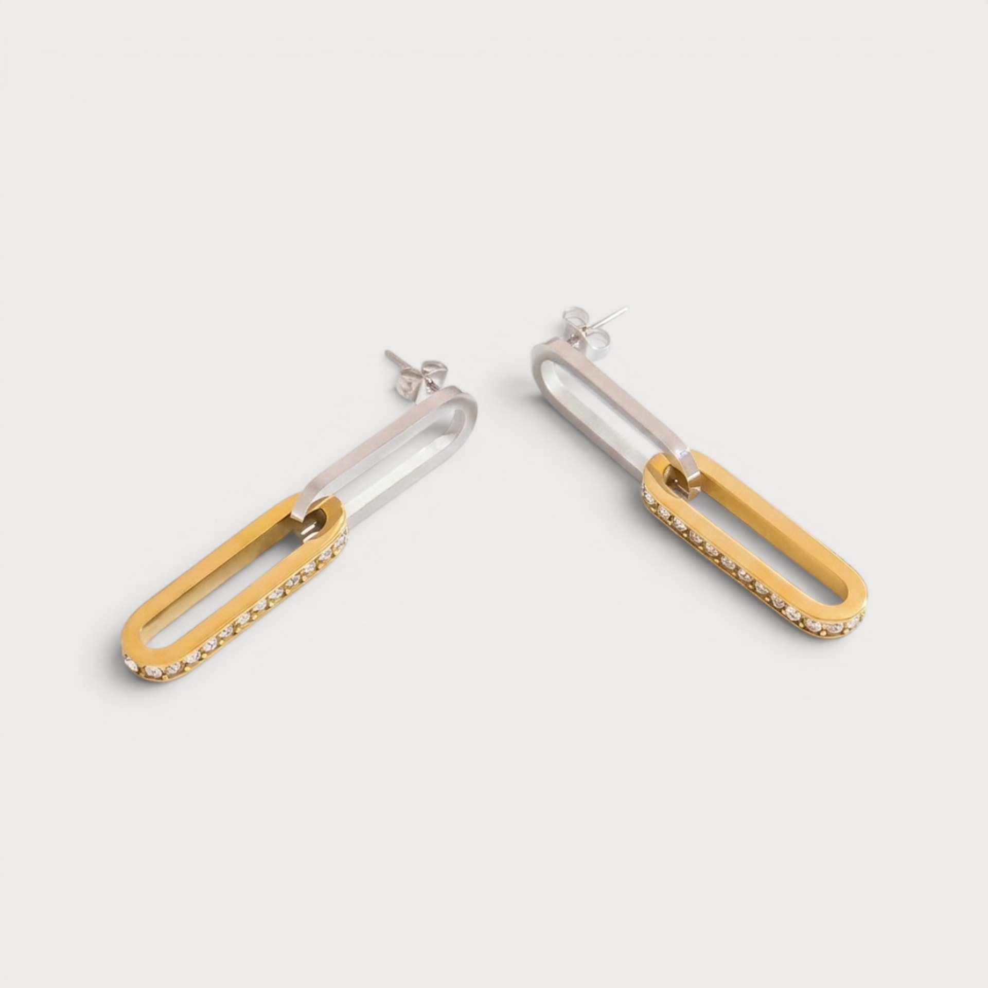Boucles Abeline bicolores, deux anneaux allongés entrelacés dont un doré bordé de pierres claires