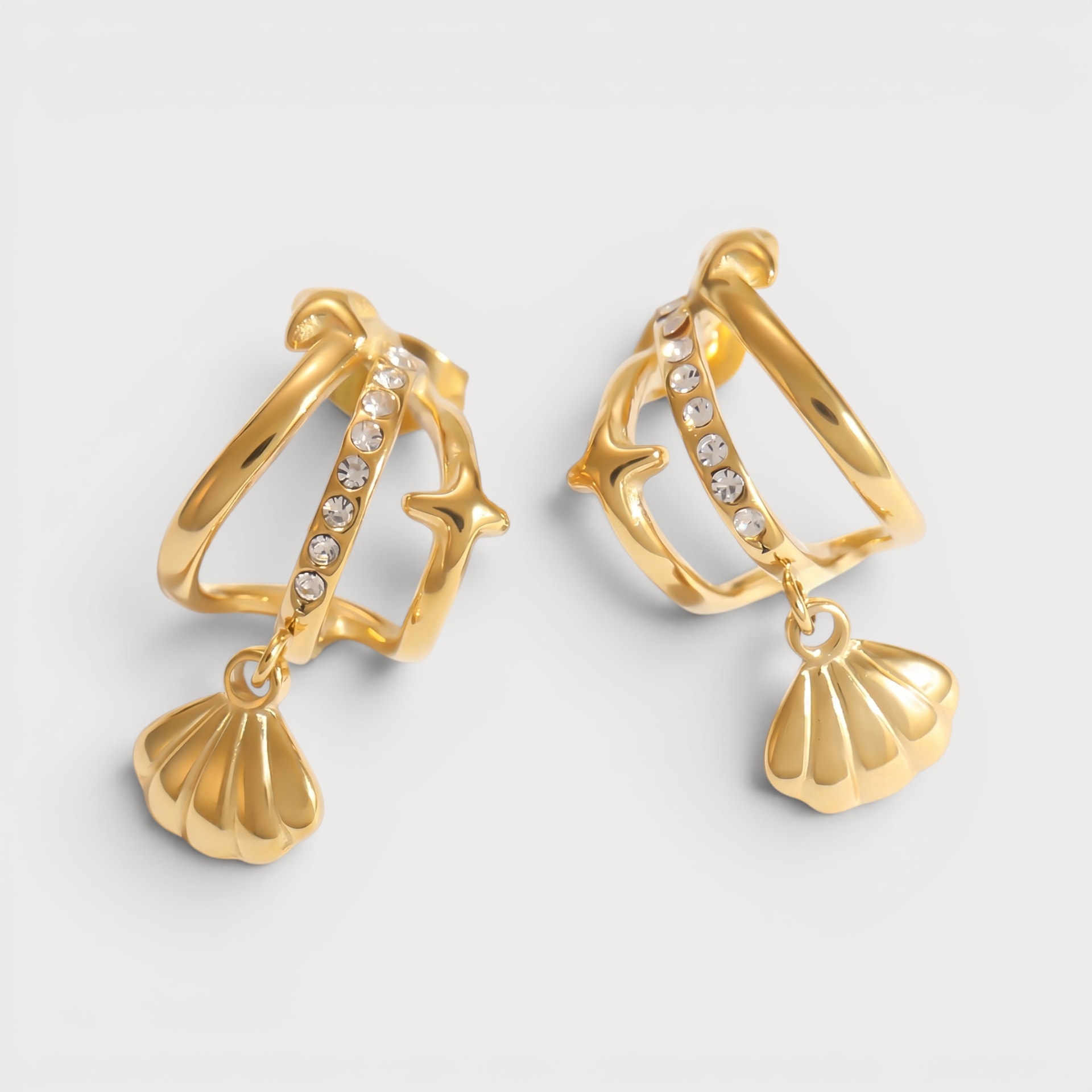 Créoles Soumaya dorées, ligne de pierres claires, étoile et coquillage pendant