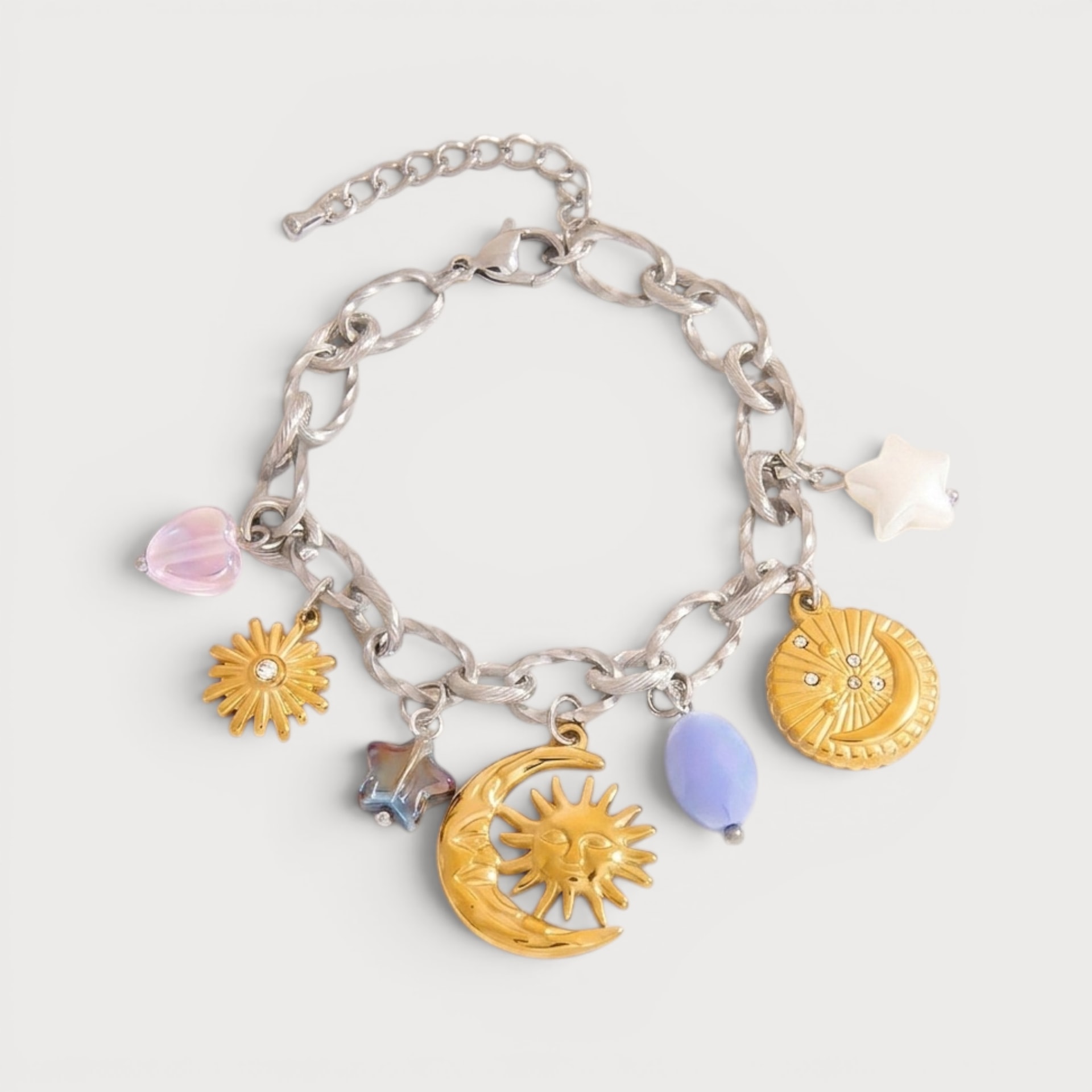 Bracelet Jeanne-Thérèse : une chaîne argentée porte des soleils, une lune et des détails pastel, dont une étoile blanche.